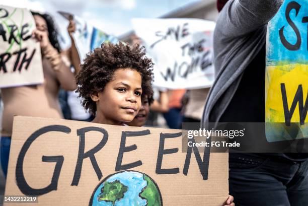 boy protesting in the street - climate march stock pictures, royalty-free photos & images