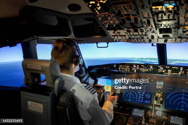 männlicher pilot im cockpit eines flugzeugjets - pilot stock-fotos und bilder