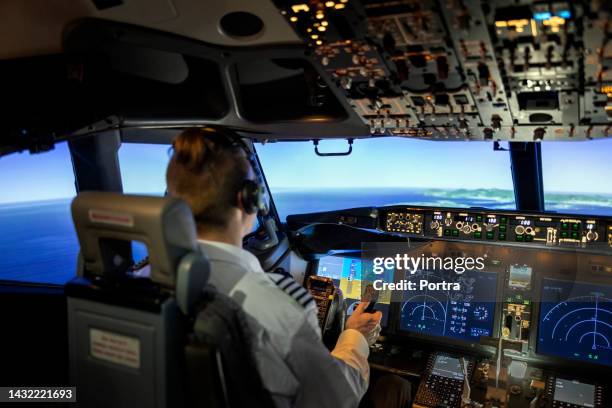 male pilot in cockpit of airplane jet - airline pilot stock pictures, royalty-free photos & images