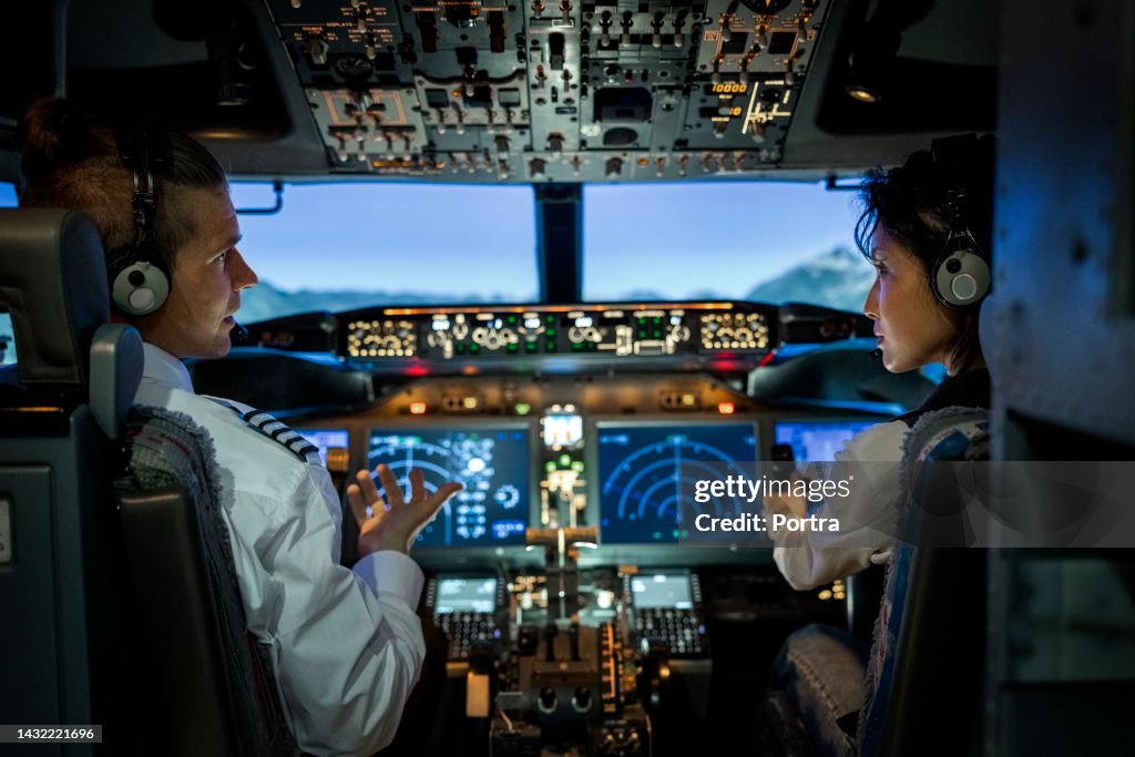 Vue arrière de deux pilotes aux commandes d’un avion commercial