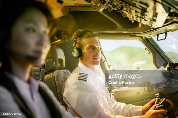 pilot with co-pilot flying a commercial jet airplane - captains day stockfoto's en -beelden