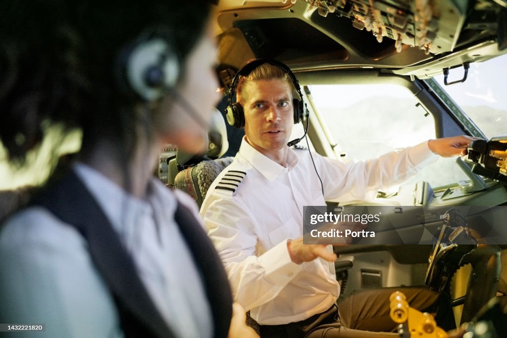 Pilot In Flight Pilot Talking With Copilot In The Cockpit During Flight Simulation High ...
