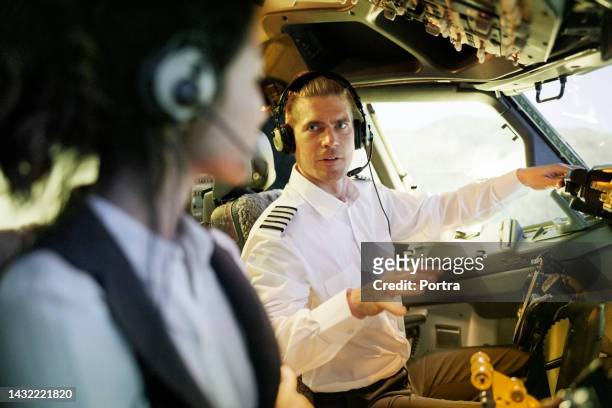 pilot talking with co-pilot in the cockpit during flight simulation - pilot simulator stock pictures, royalty-free photos & images