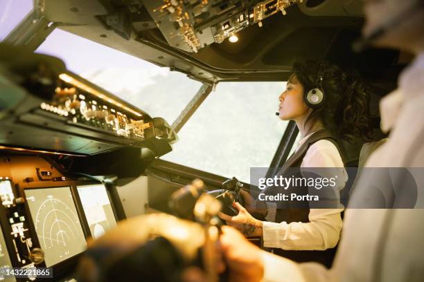 mujer piloto con un copiloto volando un avión comercial - co pilot fotografías e imágenes de stock