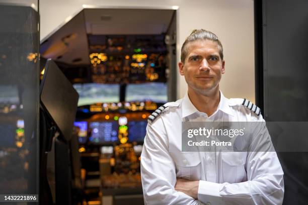 instructor masculino de pie en un hangar de simulador de vuelo - simulador de vuelo fotografías e imágenes de stock