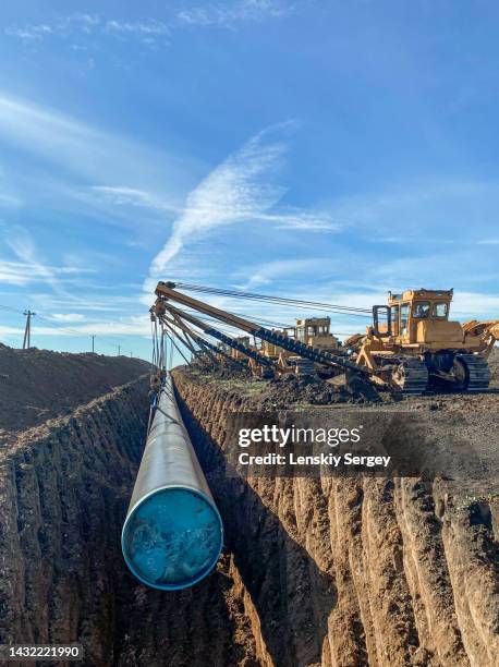 crane building gas pipeline construction on ground - wellentunnel stock-fotos und bilder