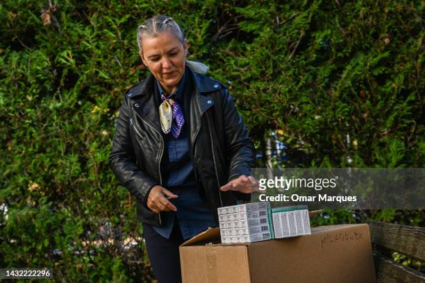 Woman shows Iodine tablets as she arrives at the Mayor's office that is one of the distribution points on October 10, 2022 in Milanowek, Poland....