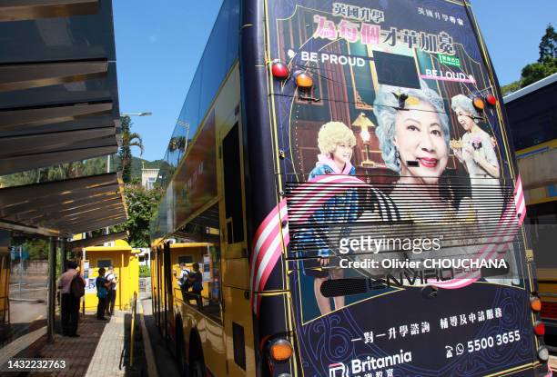 Sosie asiatique de la reine Elisabeth II sur une publicité pour des cours d'anglais à l'arrière d'un bus le 3 octobre 2022 à Hong Kong.