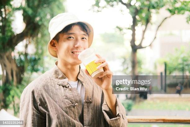 fashion asian young man drinking - asain model men stock-fotos und bilder