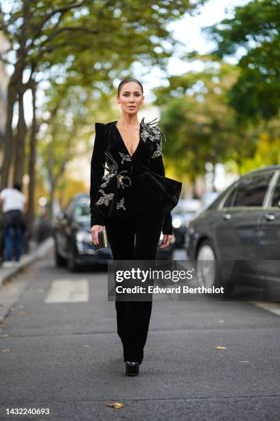 Sabina Jakubowicz wears a black velvet with embroidered gray / gold / blue embroidered sequined jewels / V-neck / shoulder-pads jacket, matching...