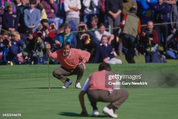 Seve Ballesteros from Spain representing Team Europe lines up a putt with the help of compatriot playing partner Jose Maria Olazabal in their morning...