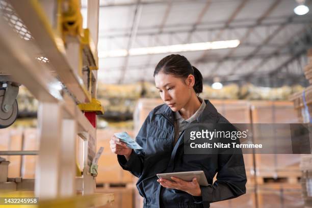 lot tracking for inventory management explained. a female warehouse leader check on a control tag on a shelf rack to control quality and quantity to confirm the authenticity of the product in a distribution warehouse. - verification stock pictures, royalty-free photos & images