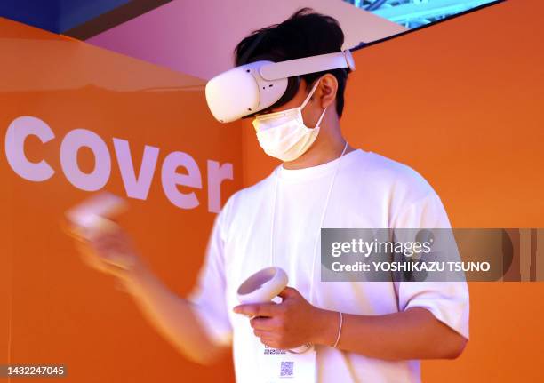 Jeune homme jouant à un jeu vidéo avec un casque de réalité virtuelle "Meta Quest 2" lors du Tokyo Game Show annuel à Chiba le 16 septembre 2022.