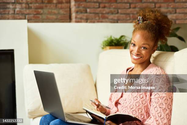 happy entrepreneur with laptop and diary - toothy smile stock pictures, royalty-free photos & images