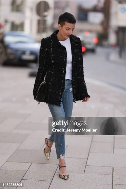 Tereza Brink wearing golden Celine heels, Chanel 2.55 big black leather bag, Chanel vintage tweed jacket, blue Agolde denim and white Zara top on...