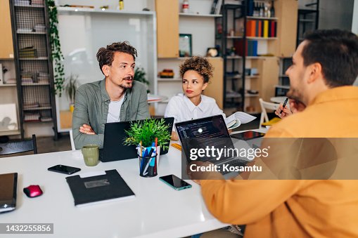 A group of people discuss the problems that occur while coding a program and how to solve them A group of people discuss the problems that occur while coding a program and how to solve them