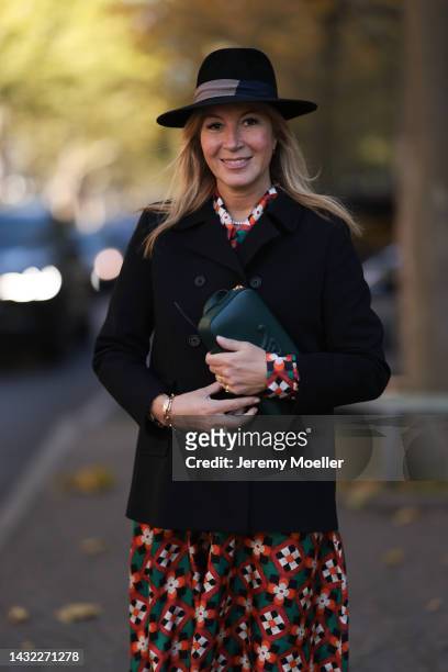 Yasmin von Schlieffen-Nannen wearing black Destree hat, Celine dark green bag, colorful Odeeh dress and black Paul & Joe jacket on October 07, 2022...