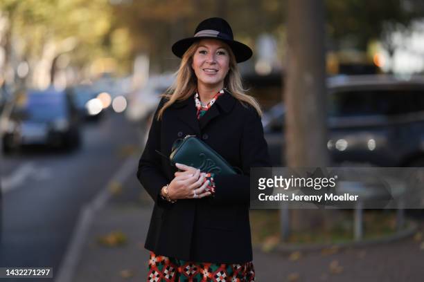 Yasmin von Schlieffen-Nannen wearing black Destree hat, Celine dark green bag, colorful Odeeh dress and black Paul & Joe jacket on October 07, 2022...
