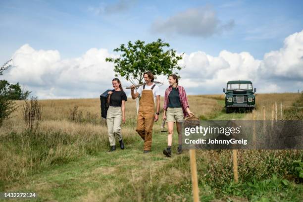 smiling farmers walking and talking on grassy path - holding tool stock pictures, royalty-free photos & images