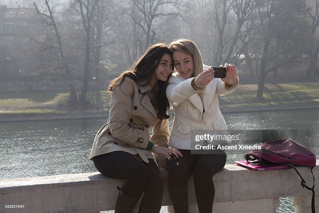 Teenage girls take picture of themselves, railing