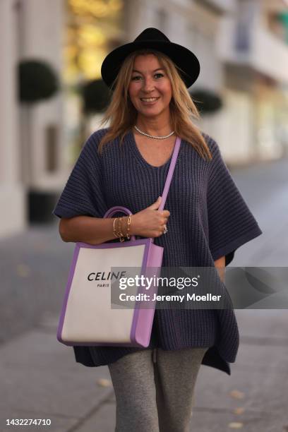 Yasmin von Schlieffen-Nannen wearing Celine lilac beige bag, Iris von Armin lilac knit poncho, grey LouLou Studio pants, black Destree hat on October...