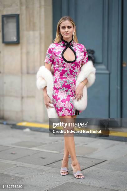 Valentina Ferragni wears crystals pendant earrings, a neon pink with pale pink / and green flower print pattern with cut-out chest / short sleeves /...