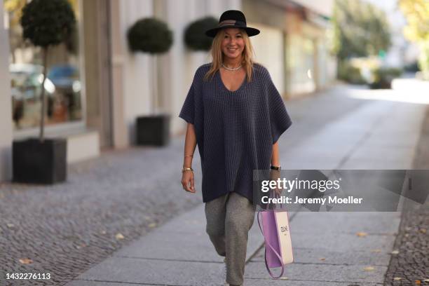 Yasmin von Schlieffen-Nannen wearing Celine lilac beige bag, Iris von Armin lilac knit poncho, grey LouLou Studio pants, black Destree hat on October...