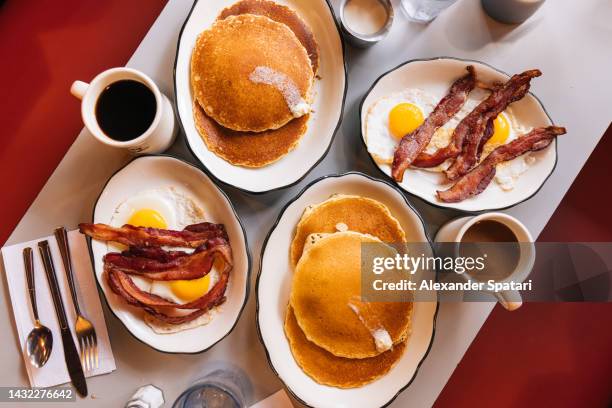 american breakfast at the diner with fried eggs, bacon and pancakes - american breakfast stockfoto's en -beelden