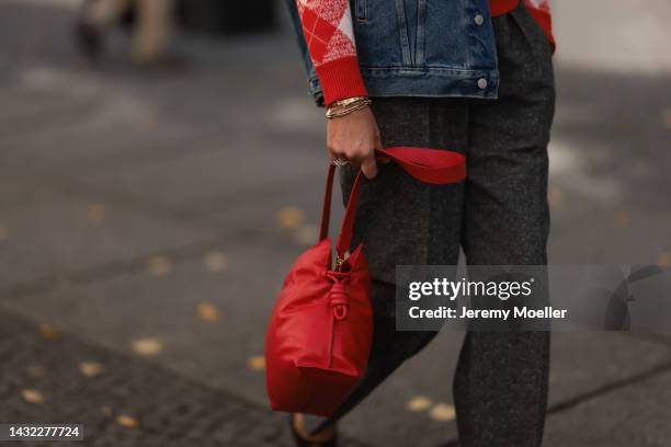 Yasmin von Schlieffen-Nannen wearing blue Acne Studios jeans jacket, red Essential Antwerp sweater, red Loewe bag, Isabel Marant Etoile pants on...