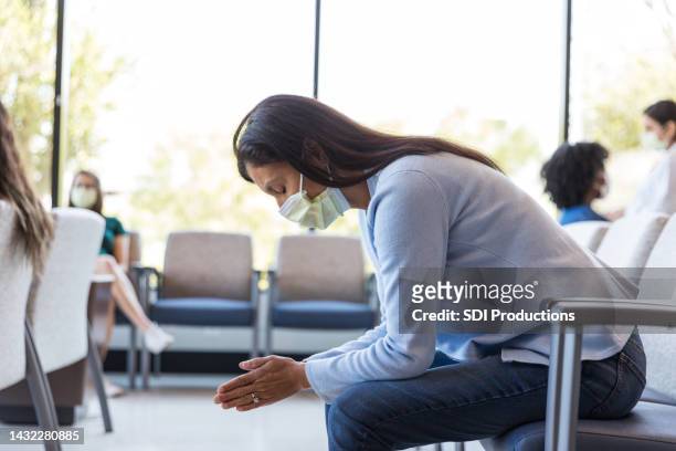 in er waiting area, woman prays about difficult decisions - nurse meditating stock pictures, royalty-free photos & images