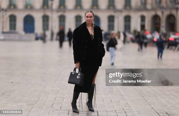 Nina Suess is seen wearing gold earrings, gold pendant necklaces, black long slit dress, black fluffy wool Saint Laurent jacket, black leather Lady...