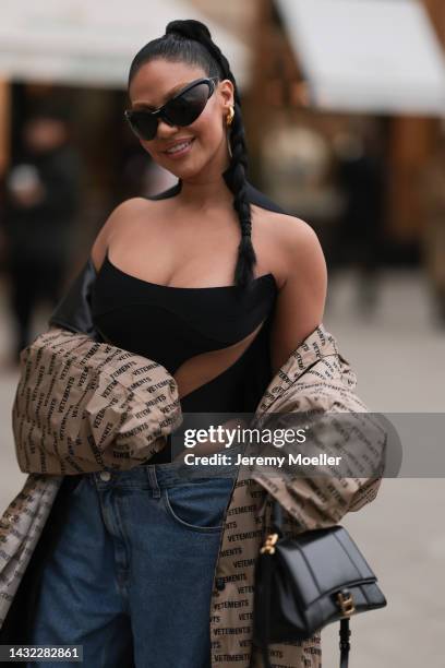 Sofia Ghasab is seen wearing gold earrings, black Balenciaga sunglasses, black transparent Mugler top/body, blue denim wide leg cargo pants, beige...