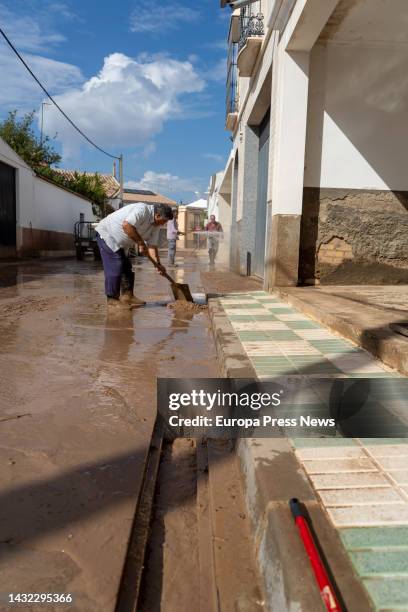 Neighbor cleans the door of his home after the flooding suffered this morning by a torrential rain, October 10, 2022 in Seville . In the Sierra Sur...