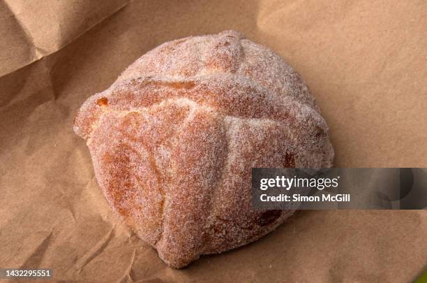 pan de muerto on a brown paper takeout bag - pan de muerto stockfoto's en -beelden