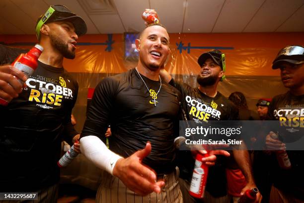 Manny Machado of the San Diego Padres celebrates with his teammates in the locker room after defeating the New York Mets in game three to win the...