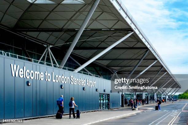 passengers outside london stansted airport - luchthaven londen stansted stockfoto's en -beelden