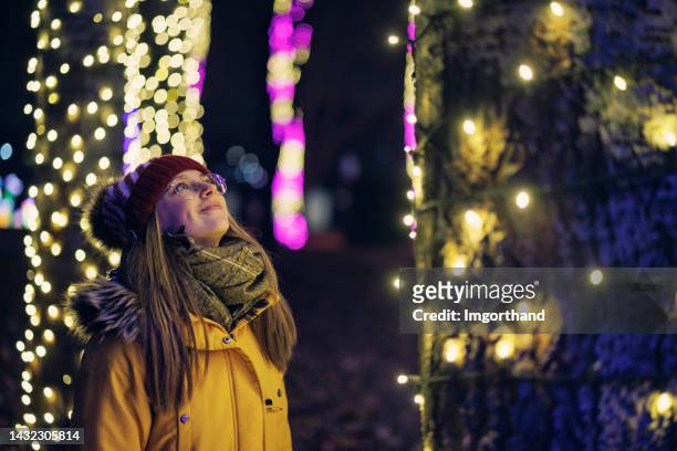 l'adolescente sta guardando le luci di natale nel parco pubblico - daily life during christmas season in poland foto e immagini stock