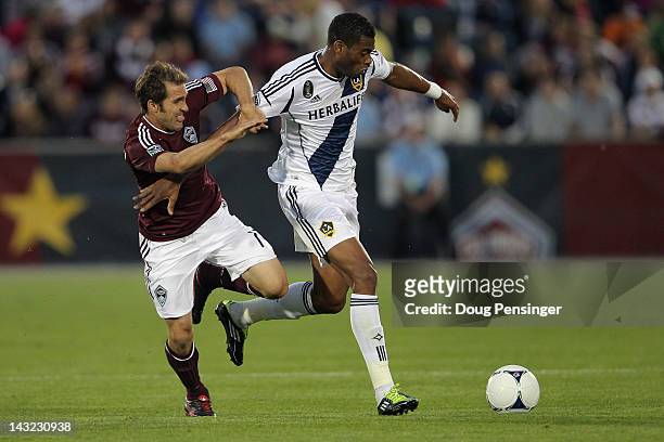 David Junior Lopes # of the Los Angeles Galaxy controls the ball while under pressure from Brian Mullen of the Colorado Rapids at Dick's Sporting...