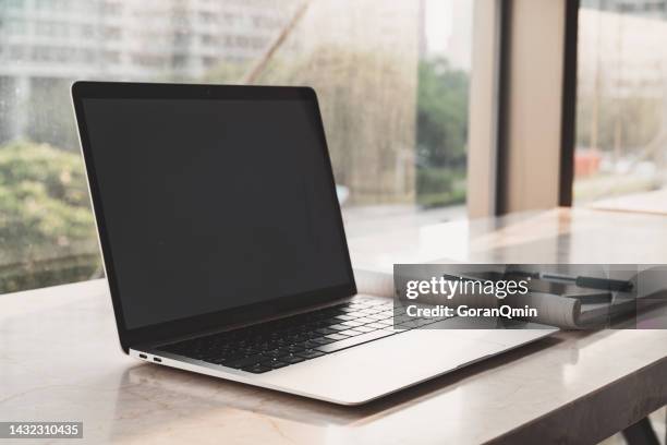 person using a laptop computer on a project on the table in open space office - open laptop on desk stock-fotos und bilder
