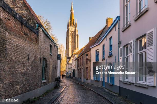 narrow cobbled street in bruges old town, belgium - flandern belgien stock-fotos und bilder