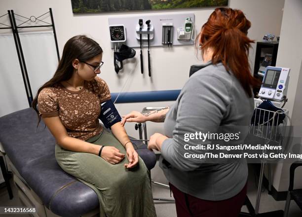 High School senior Elena Herrera, left, has her blood pressure taken by Diana Violatoro, a medical assistant at Kids First Health Care clinic at...