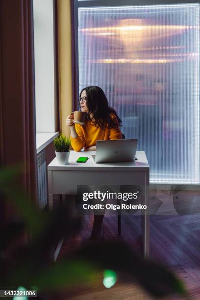 drinking coffee and relaxing before working day in office. assistance and secretary job for young women - desk with green space view stock pictures, royalty-free photos & images