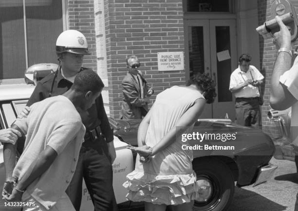Two suspects are picked up and brought into the 77th Street Police Station as the rioting continues in Watts for the 3rd day. Police have appealed...