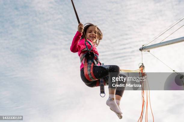 girl is jumping on a bungee trampoline - bungee jump stockfoto's en -beelden