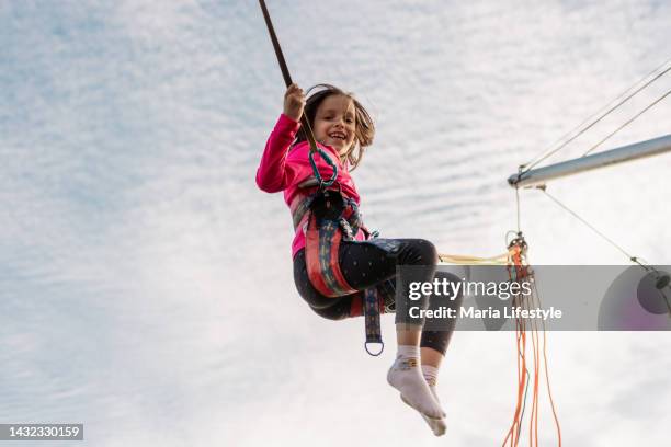 girl is jumping on a bungee trampoline - bungee jumping stock pictures, royalty-free photos & images