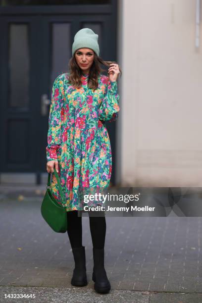 Anna Wolfers wearing a mint-colored knitted hat, colorful long dress, black tights, black boots and a green handbag on October 06, 2022 in Hamburg,...