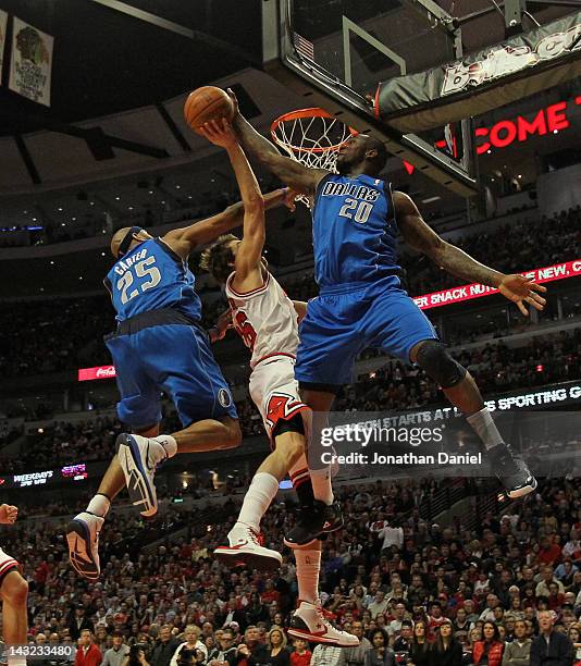 Dominique Jones of the Dallas Mavericks blocks a shot by Kyle Korver of the Chicago Bulls as Vince Carter also defends at the United Center on April...