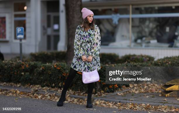 Anna Wolfers wearing a a purple knitted hat, colorful dress, black tights, black boots and a purple handbag on October 06, 2022 in Hamburg, Germany.