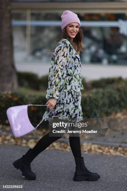 Anna Wolfers wearing a a purple knitted hat, colorful dress, black tights, black boots and a purple handbag on October 06, 2022 in Hamburg, Germany.