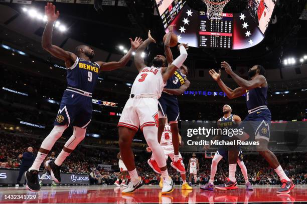 Andre Drummond of the Chicago Bulls battles for a rebound with Davon Reed and Bones Hyland of the Denver Nuggets during the first half of a preseason...